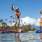 Arthur Arutkin and Seychelle Webster standup paddling with Black Project Hydro FlowX SUP paddles